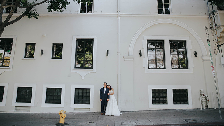 A bride and groom posing outside of Redbird