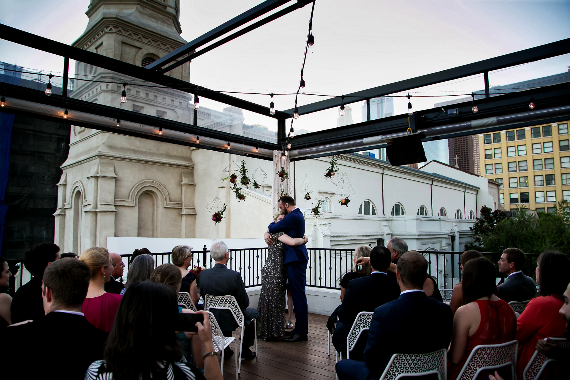 A bride and groom embracing during their wedding ceremony on the balcony