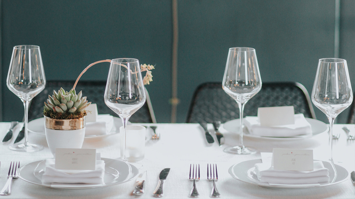 A dining arrangement in green room and all white place settings