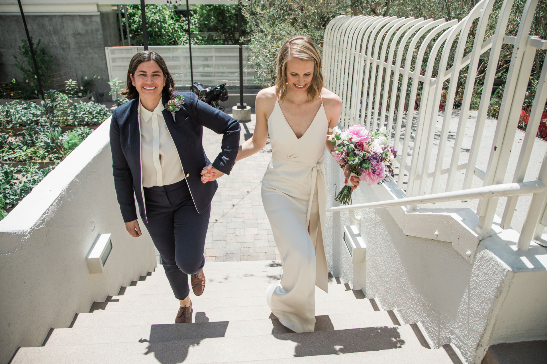 two brides walking upstairs outside