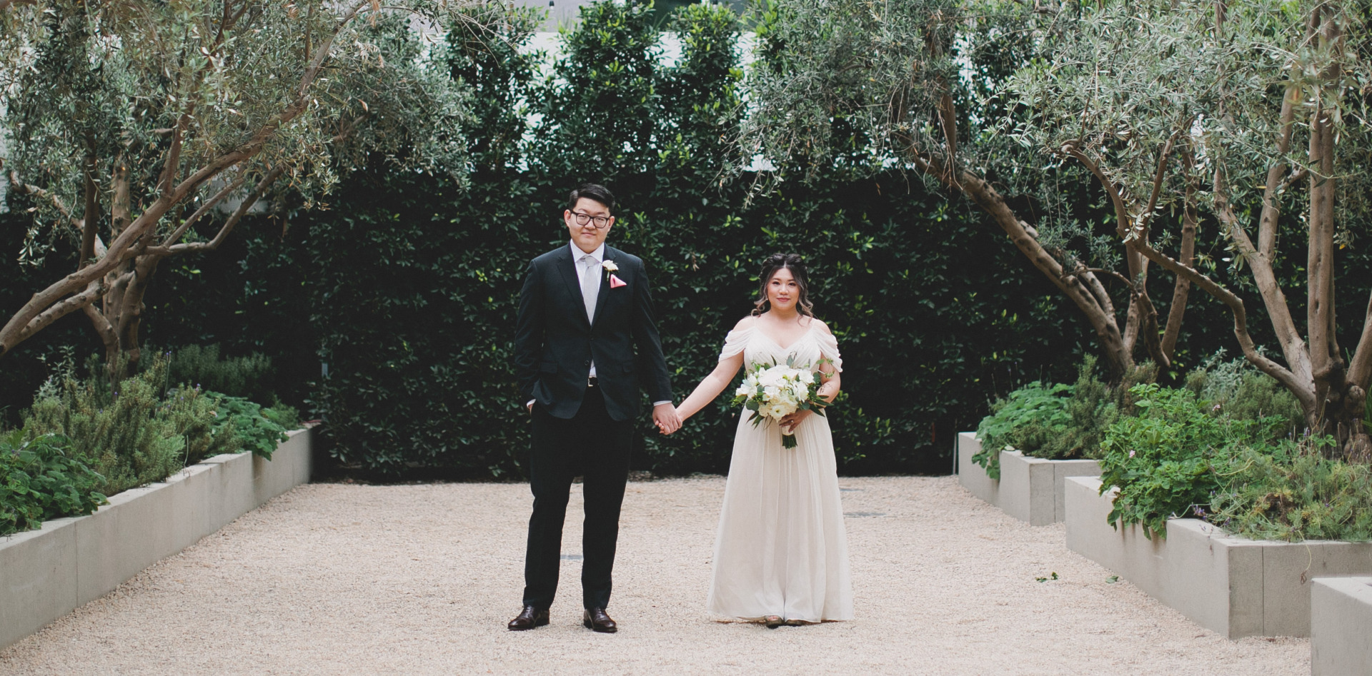 bride and groom holding hands in garden