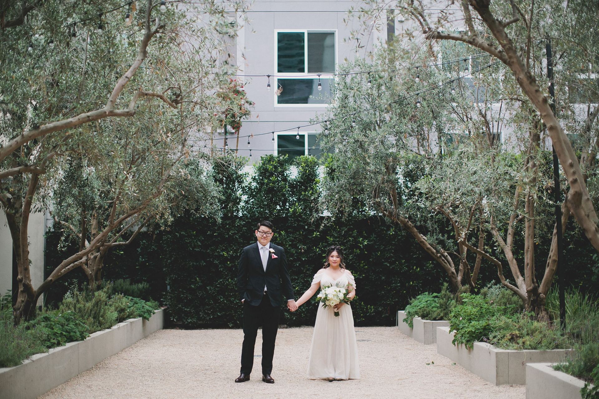 bride and groom holding hands in garden