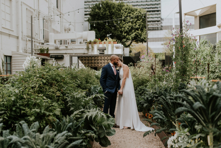 bride and groom holding each other in garden