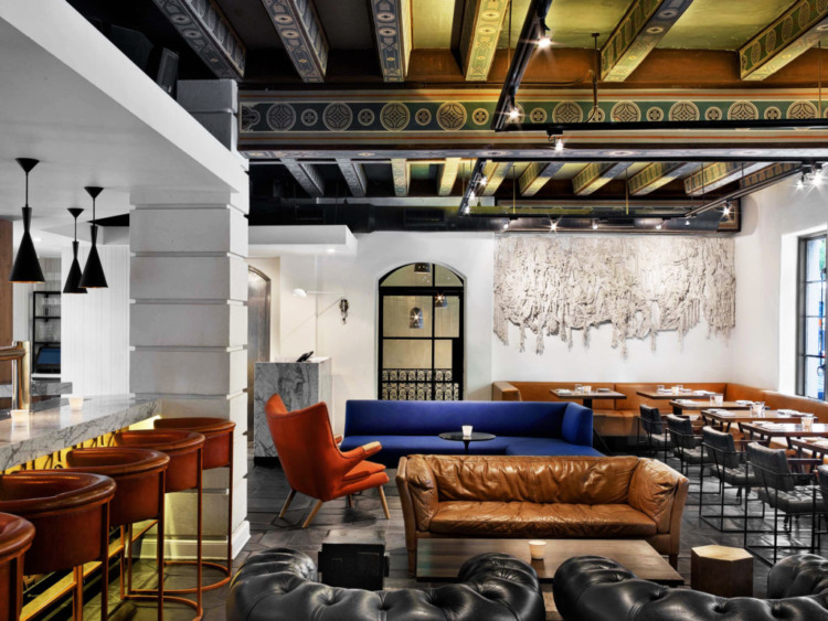 redbird dining room with white walls, bar, couches and booths along the wall.