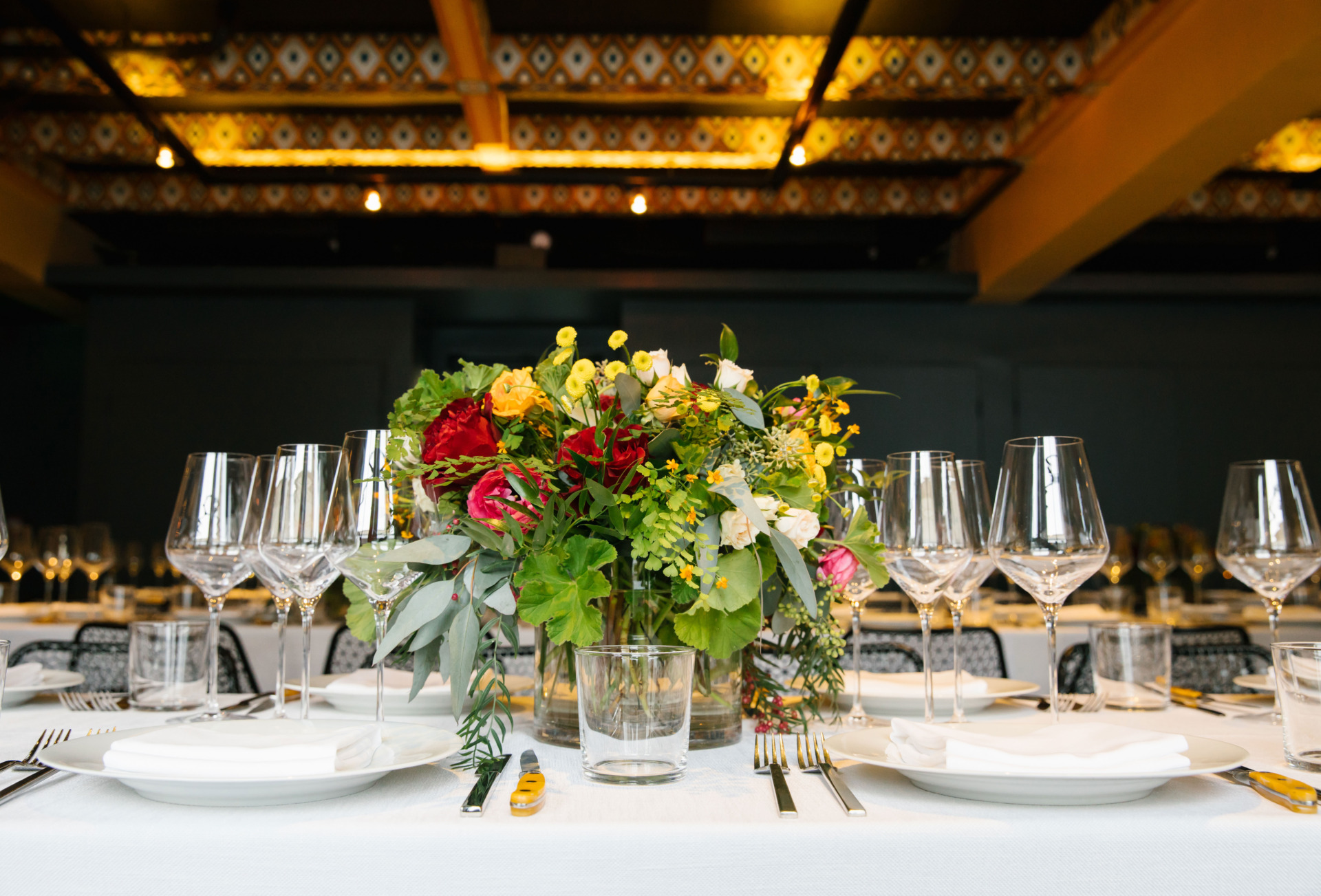 Table Setting with Red, Yellow and Green Flowers