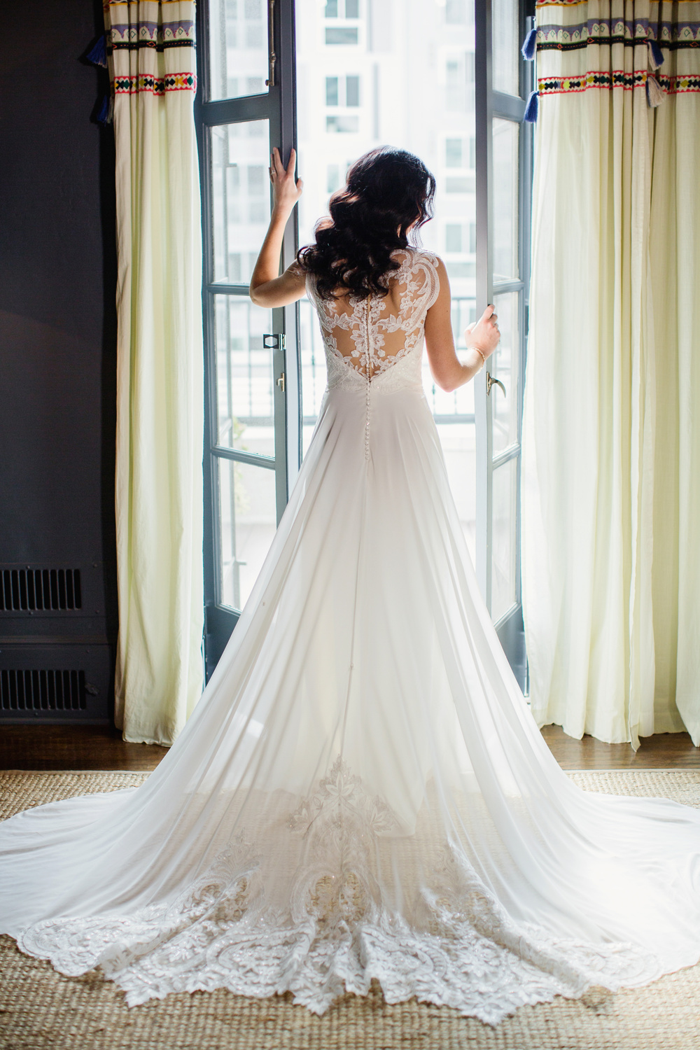 bride opening doors with colorful curtains