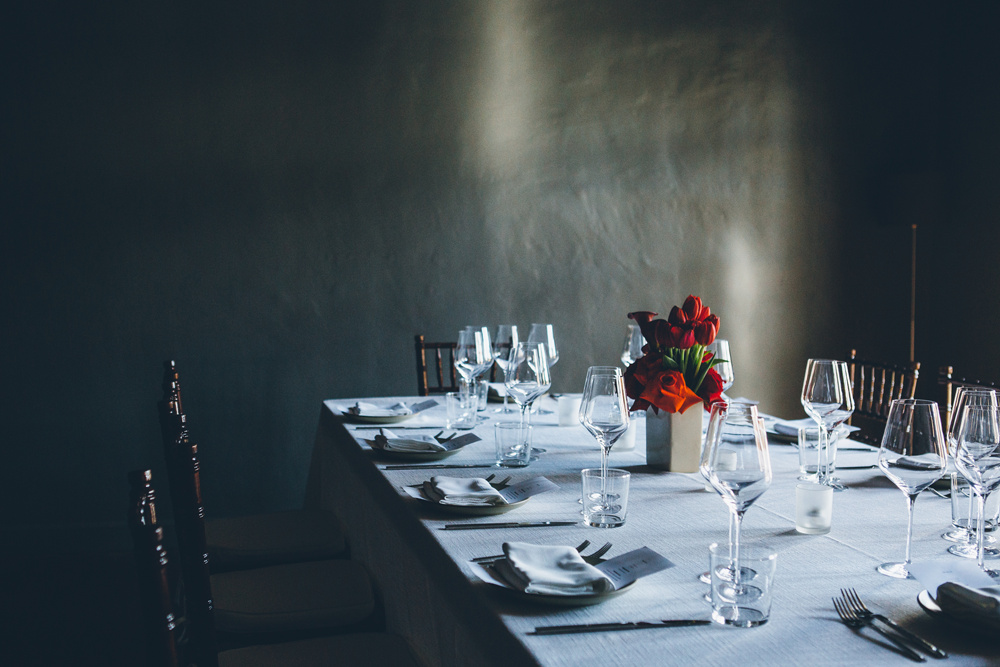 Dining Table Set with Red Flowers, Wooden chairs and White Tablecloth