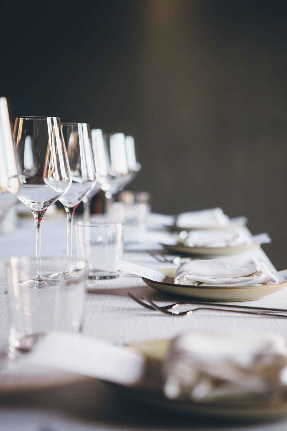 Table setting with wine glass, plate and two forks.