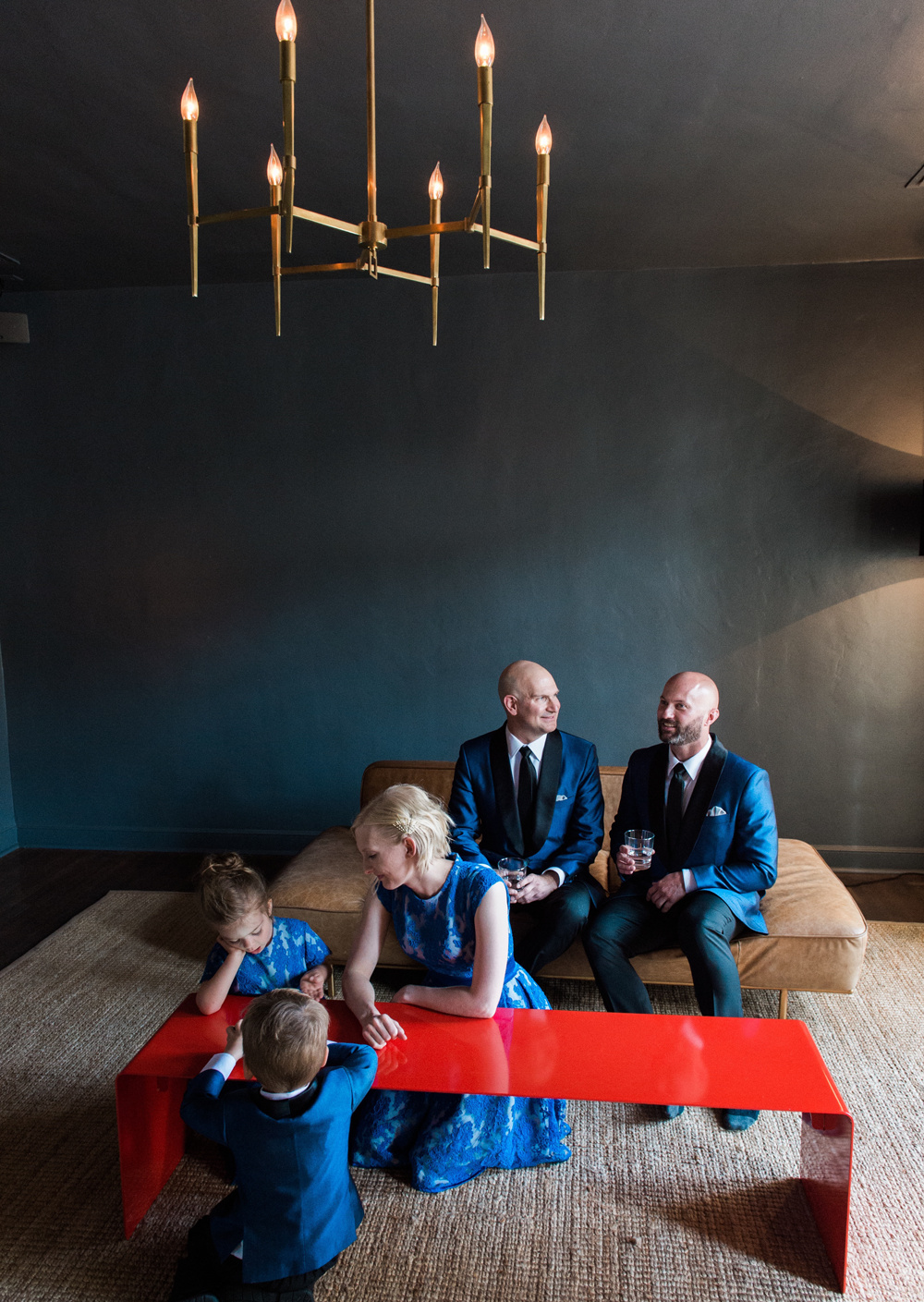 grooms with wedding friends in front and two kids, all in blue