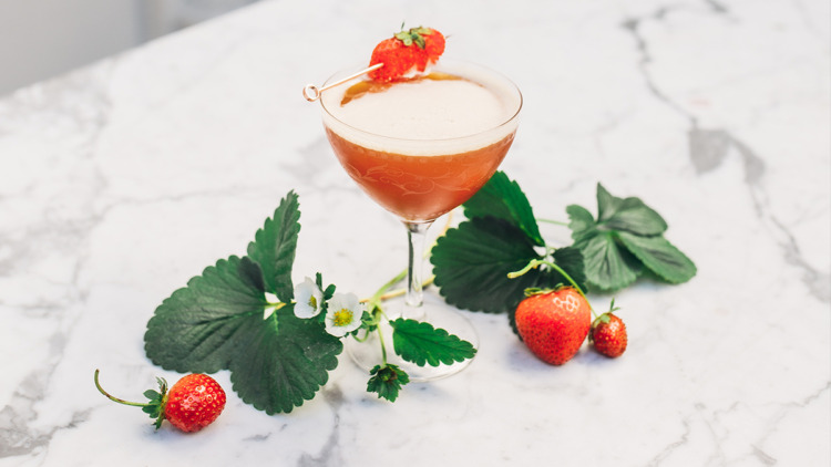 Cocktail with Strawberries Around It on marble surface