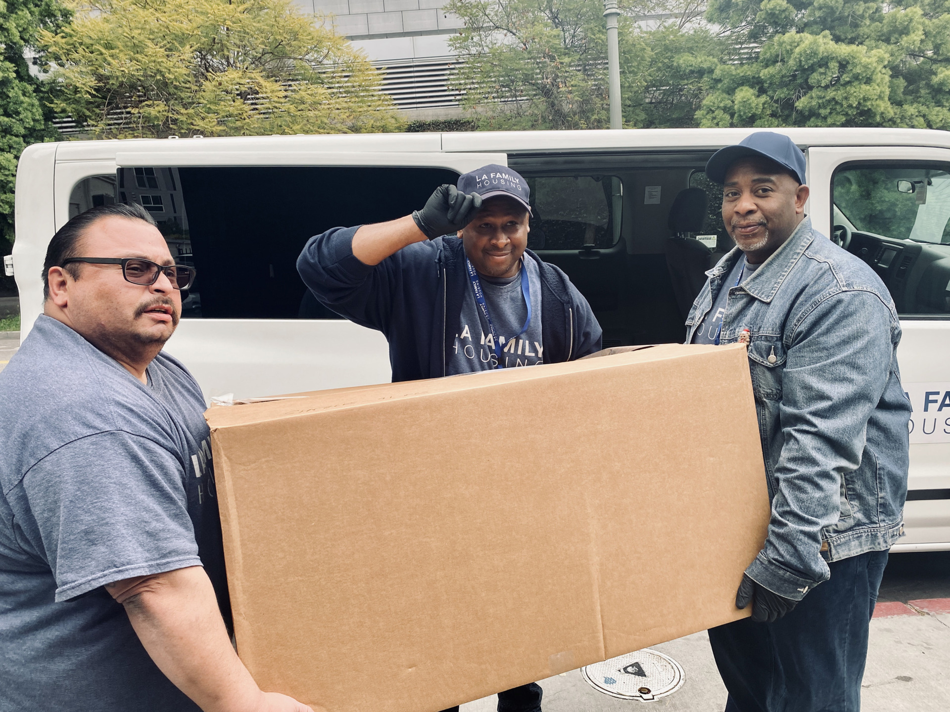 three men carrying a box