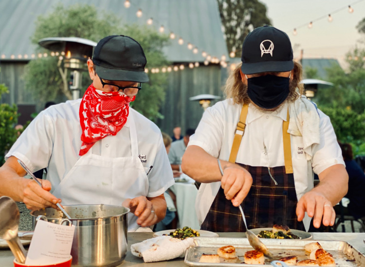 two chefs- Jason Bowlin and Neal Fraser of Redbird- cooking with hats, aprons and masks at the ojai valley inn