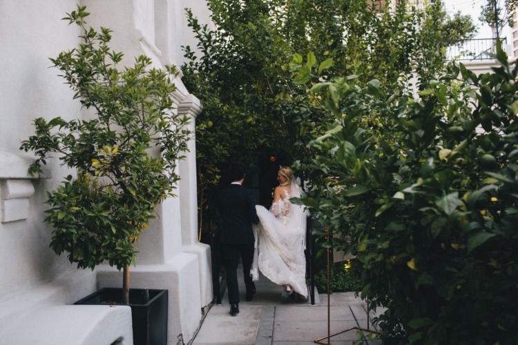 man and woman entering a tunnel of greenery