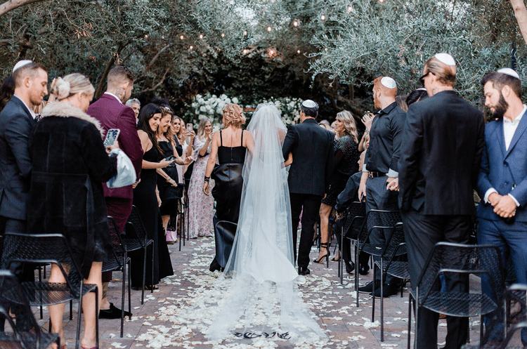 bride being walked down aisle by parents