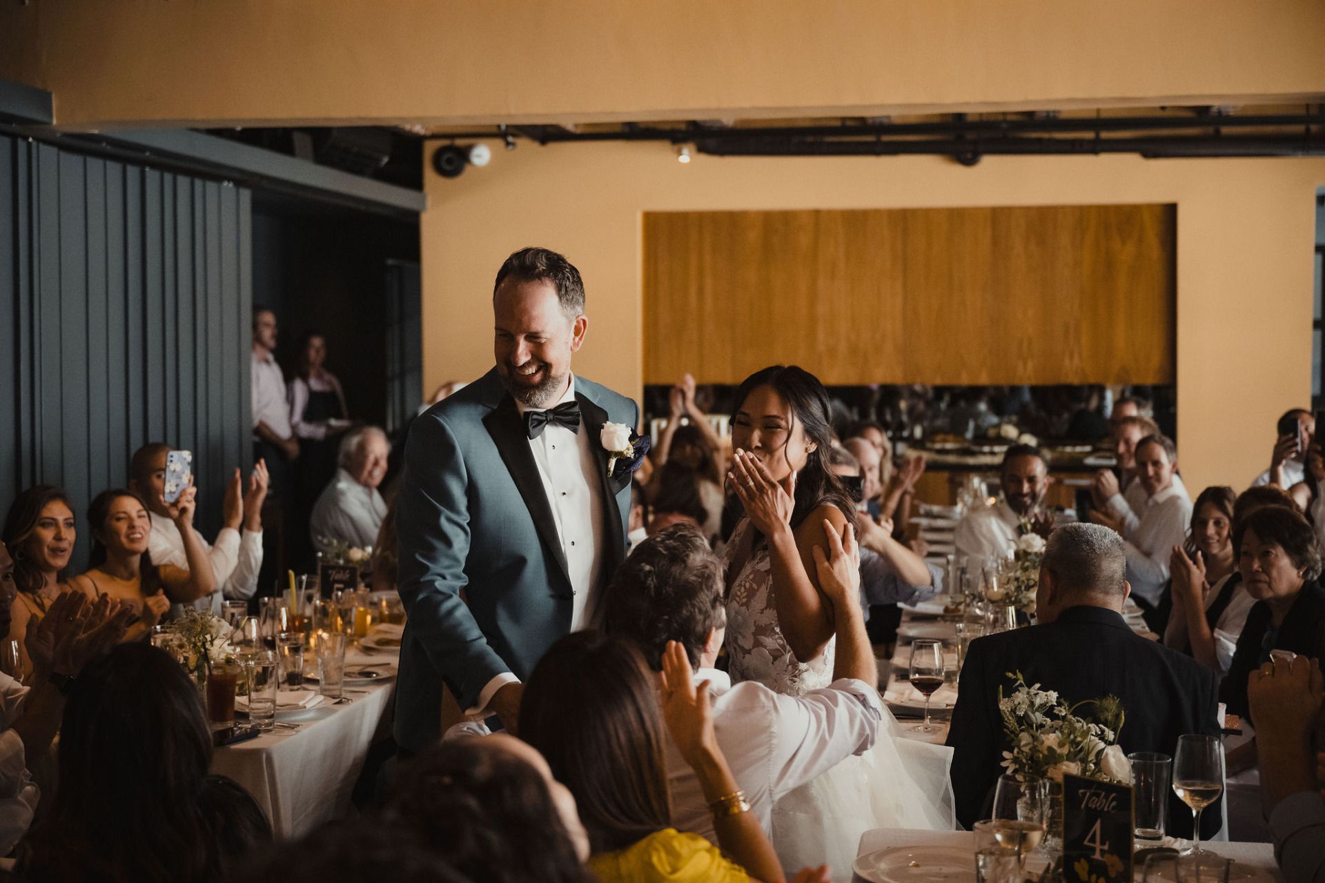 a bride and groom smile amidst their guests at their wedding in the West Room at Redbird in DTLA