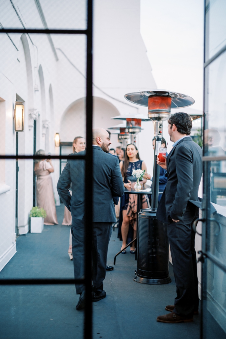 guests enjoy cocktails on the balcony of the Cardinal's Quarters in Downtown LA at Redbird