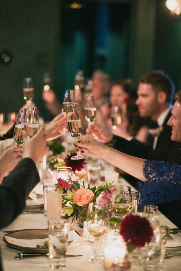 wedding guests cheers at a dinner reception in Downtown LA in Cardinal's Quarters at Redbird