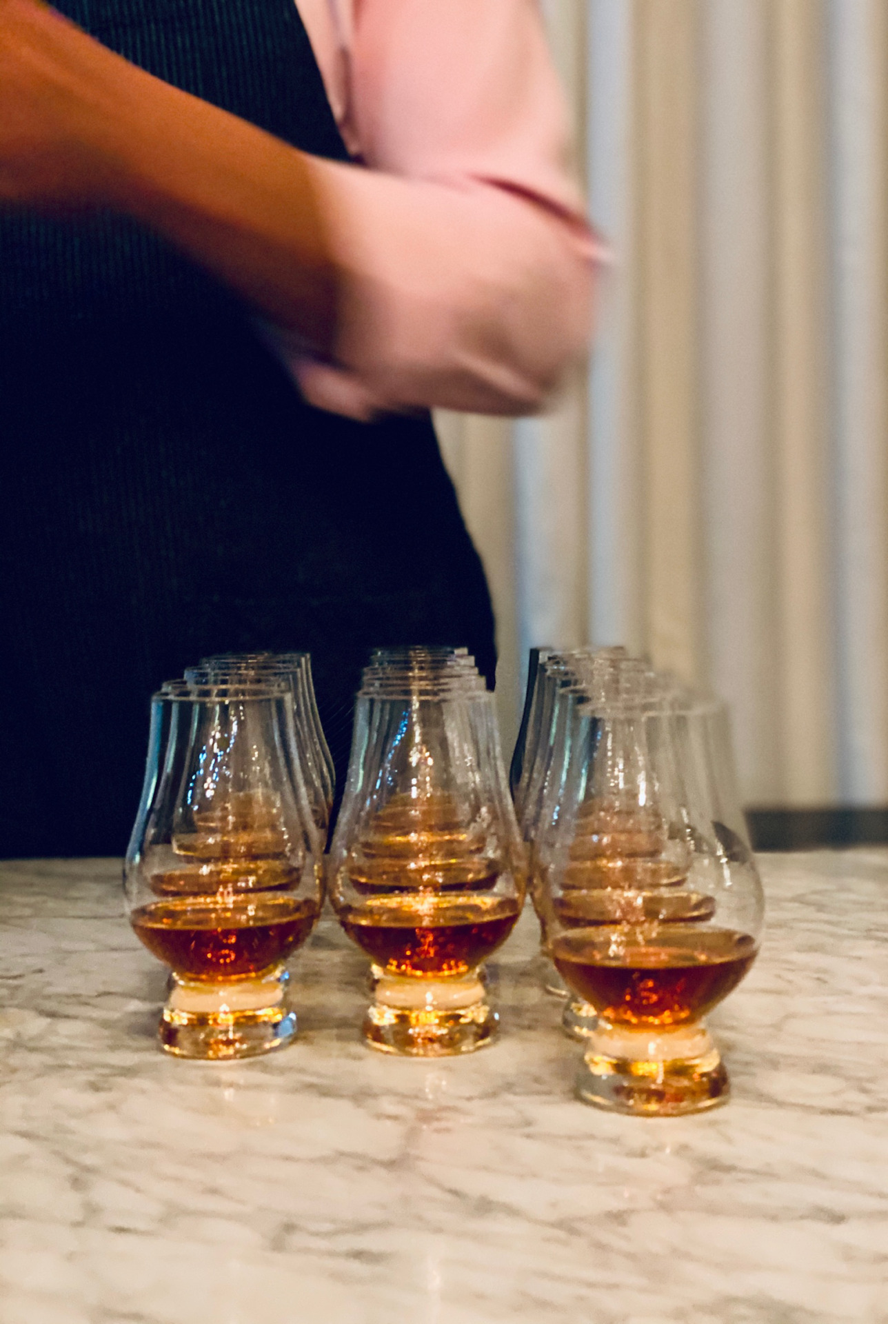 a bartender standing behind glen cairn glasses with bourbon. dtla sazerac o.f.c. vintage bourbon dinner