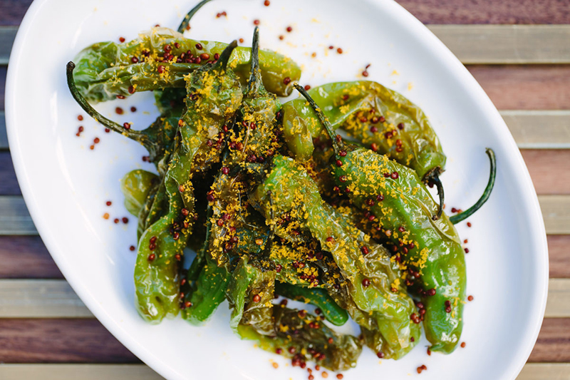 shishito peppers on a plate with quinoa and bottarga