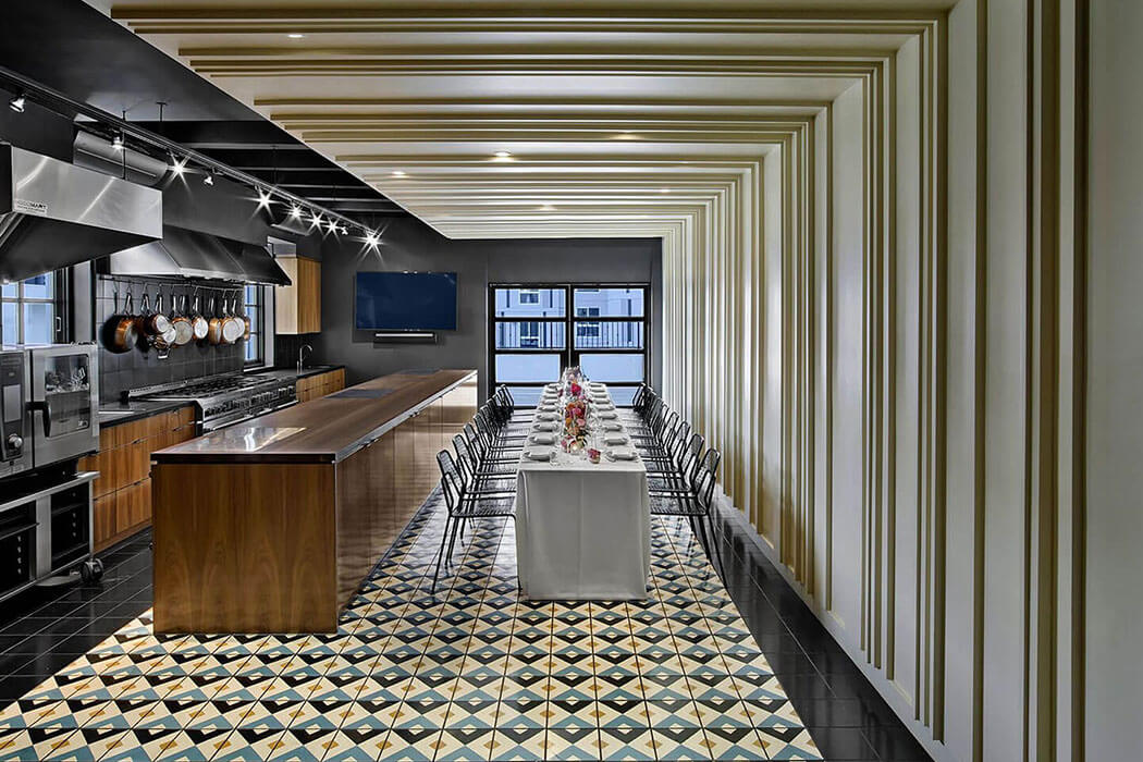 The dining room and kitchen looking out towards the open air balcony of the East Room at Redbird | Vibiana