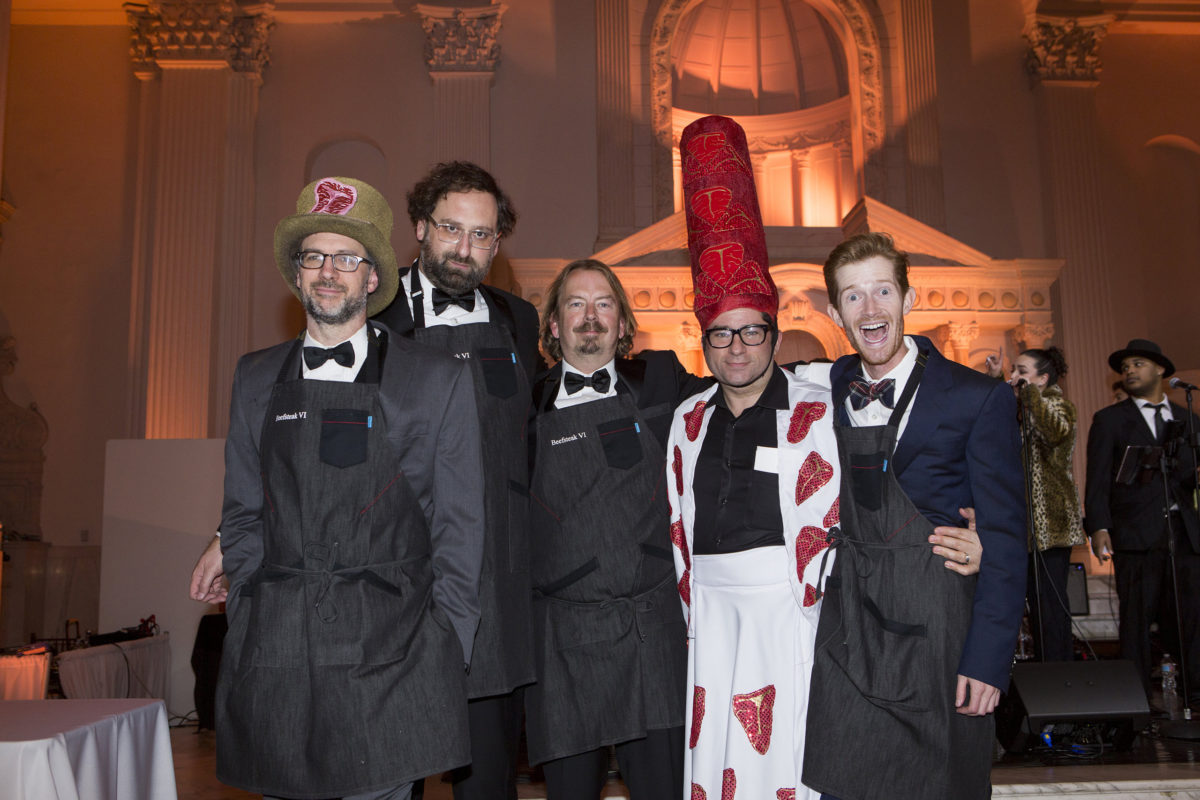 5 men in aprons and a steak costume posing for a picture