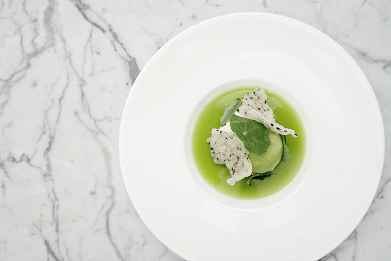 white plate with green dessert on top of a marble counter