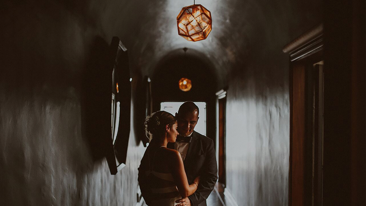 a bride and groom embracing in a hallway