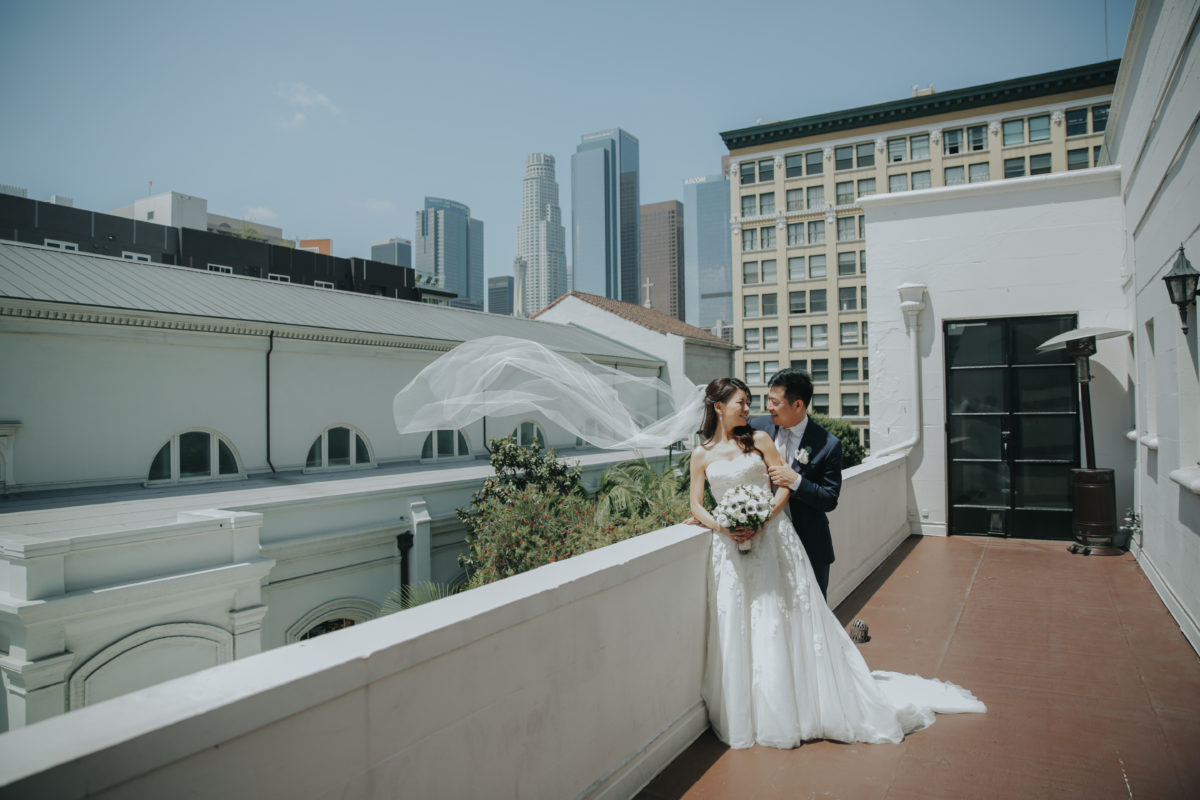 A bride and groom posing on the balcony