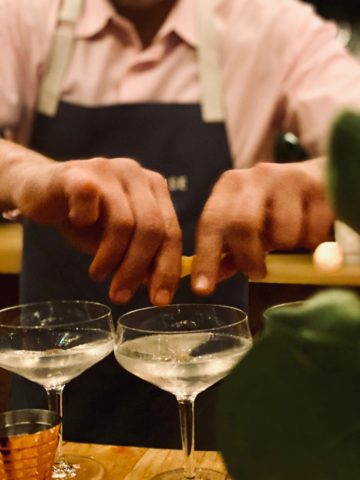 bartender expressing a lemon for a cocktail