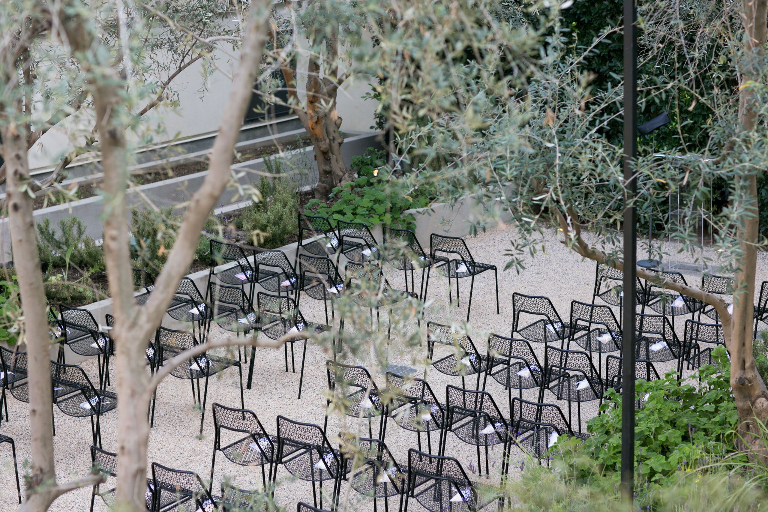 garden area set up for a wedding with black metal pattern chairs