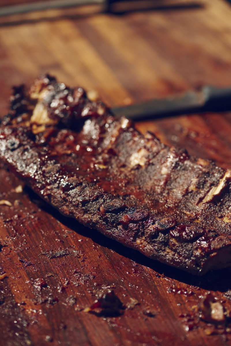 closeup of cooked ribs on a wood cutting board