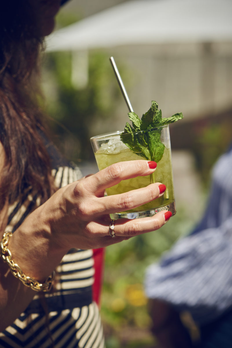 woman with red nails holding mint cocktail