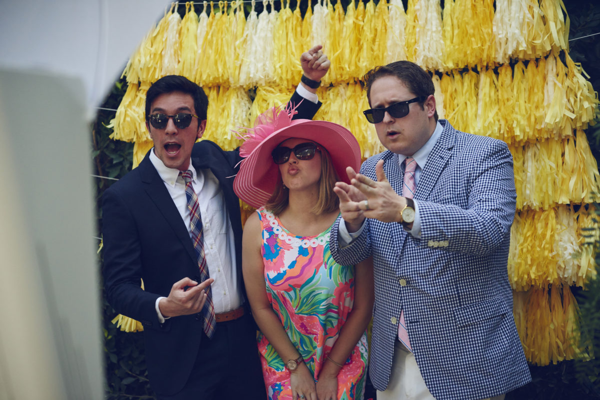 kentucky derby party photobooth with two men and woman in middle