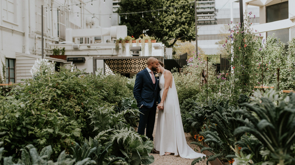 bride and groom holding each other in garden
