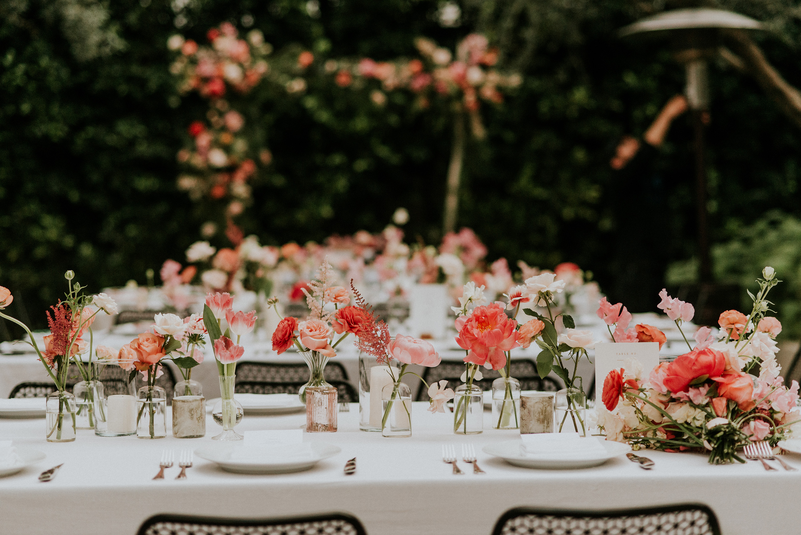 long tables set up in garden with pink flowers everywhere