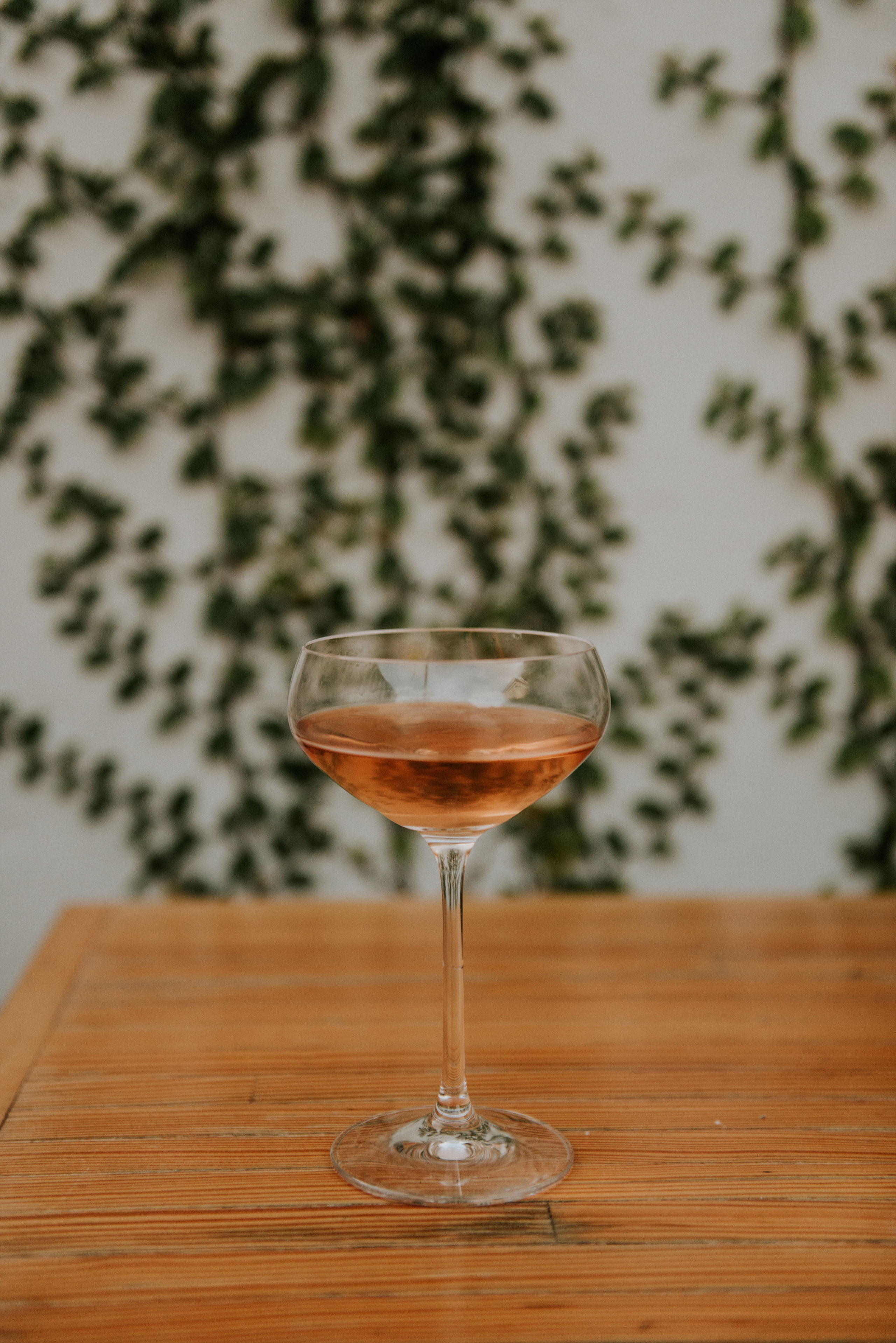 Wine glass filled with rose on wood table
