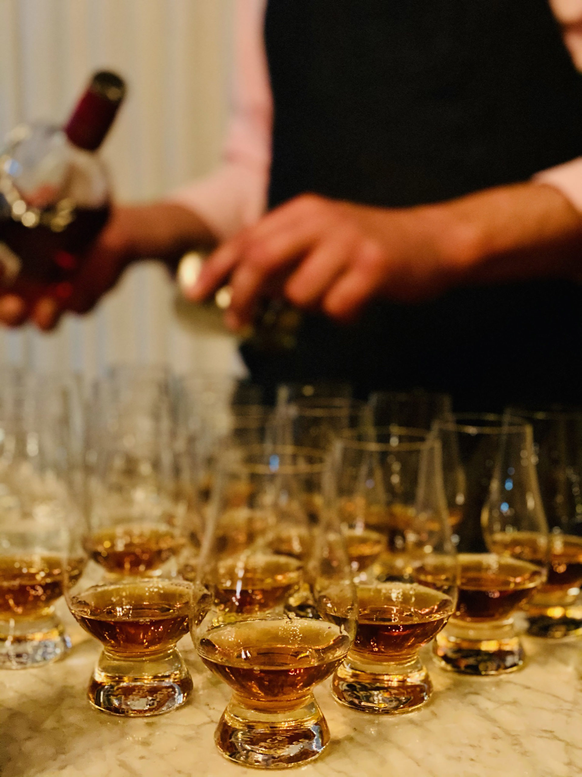 bartender hands pouring dalmore into smaller whisky tasting glasses