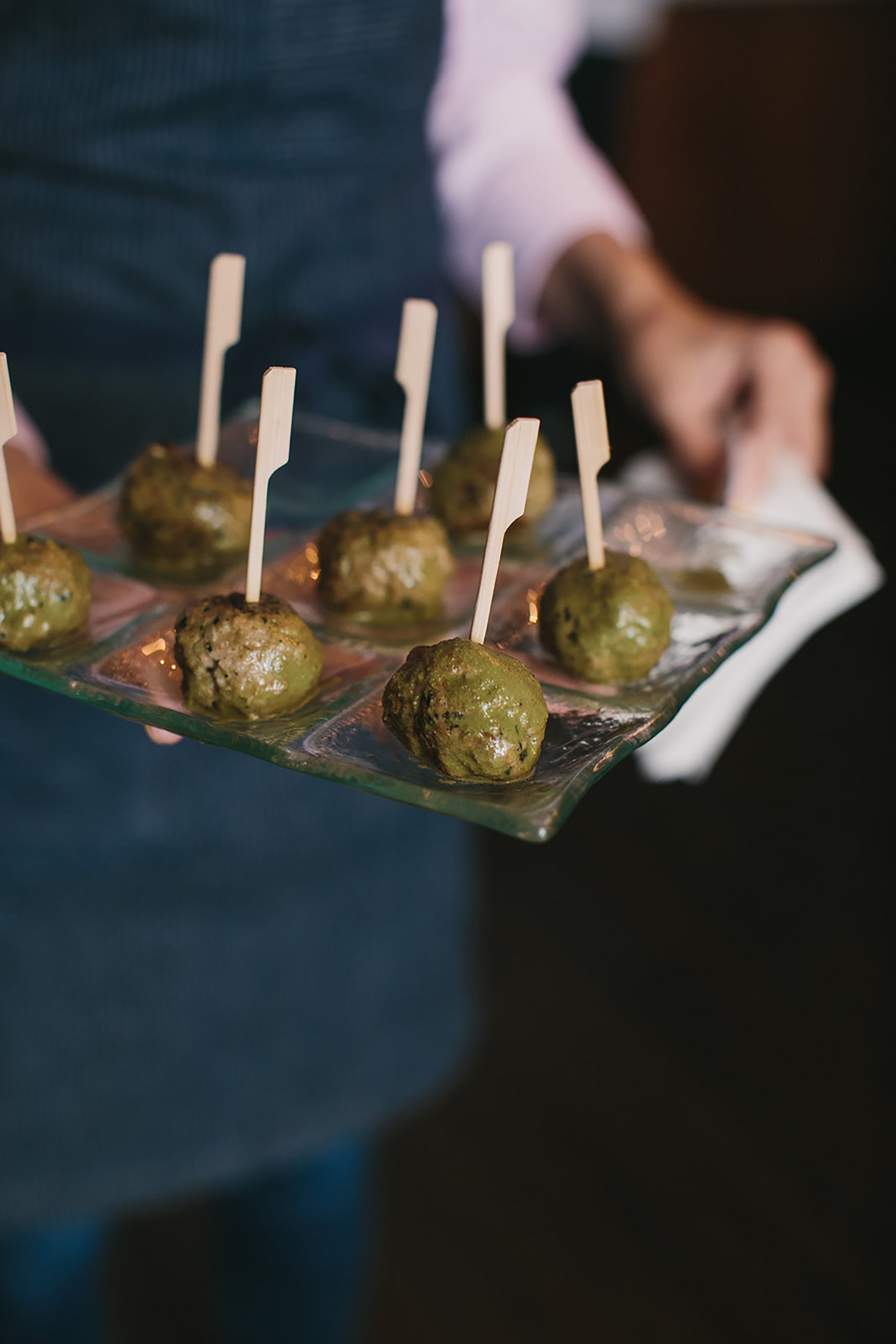 meatballs being passed on a glass tray