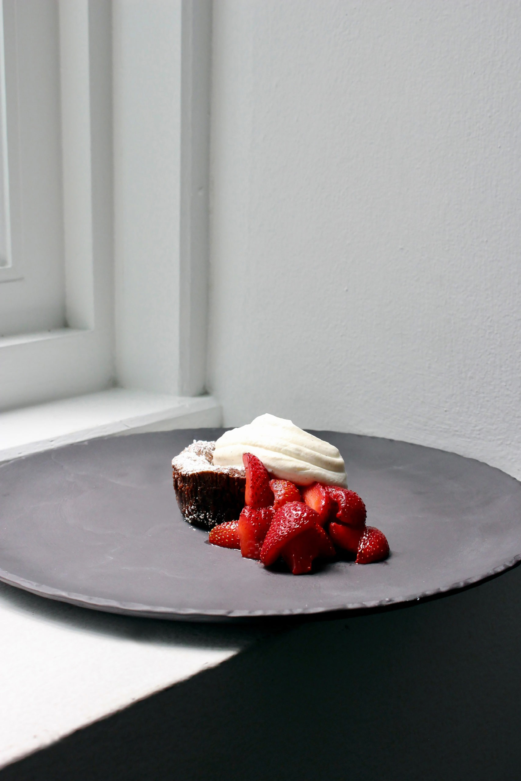 strawberry with cake and creme dessert on grey plate