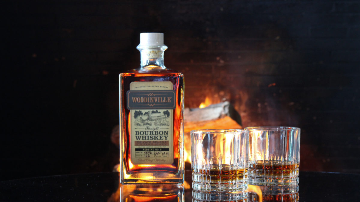 woodinville bourbon on a table with fireplace in background