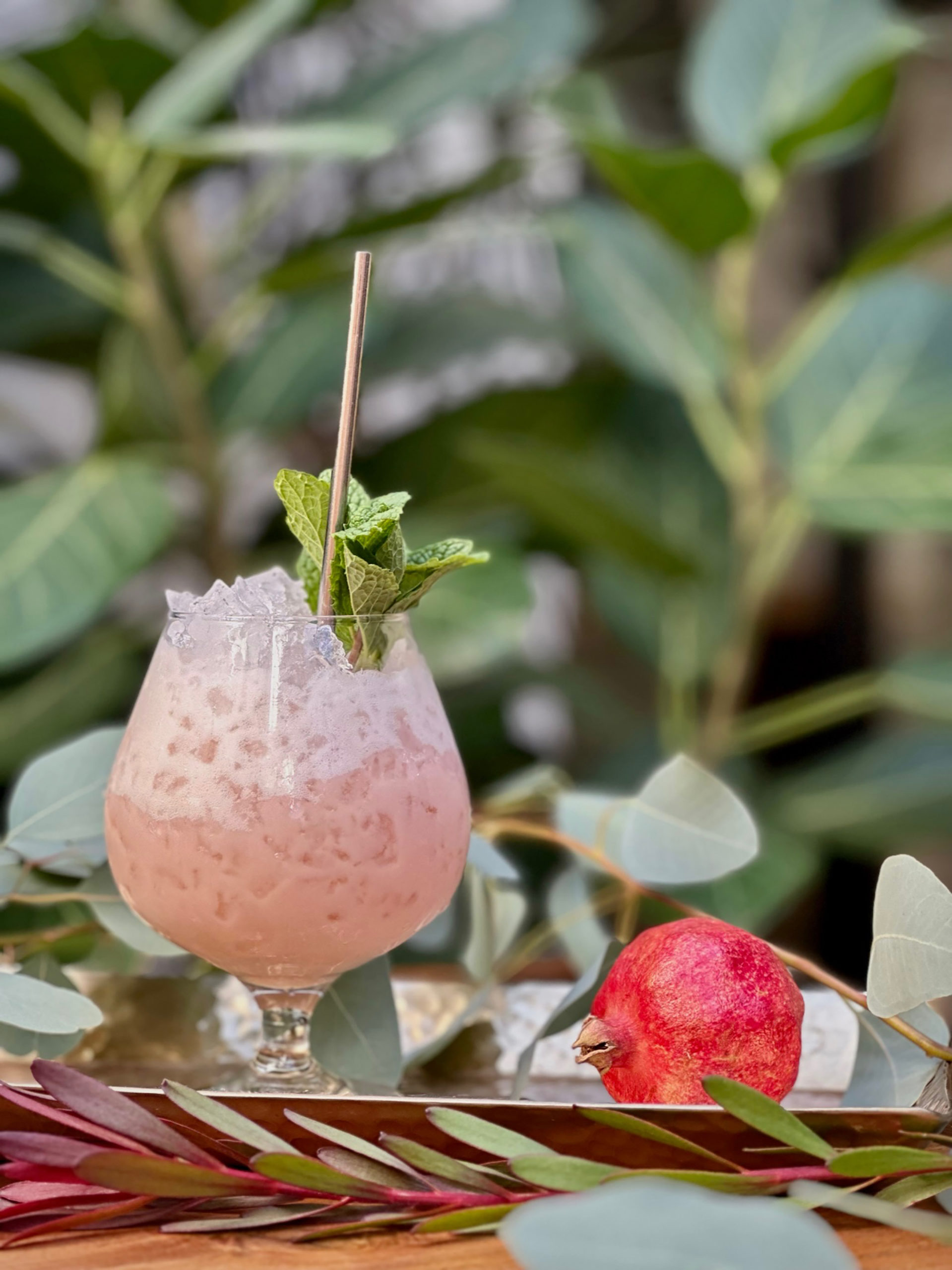 pink and foamy cocktail with mint and pomegranate