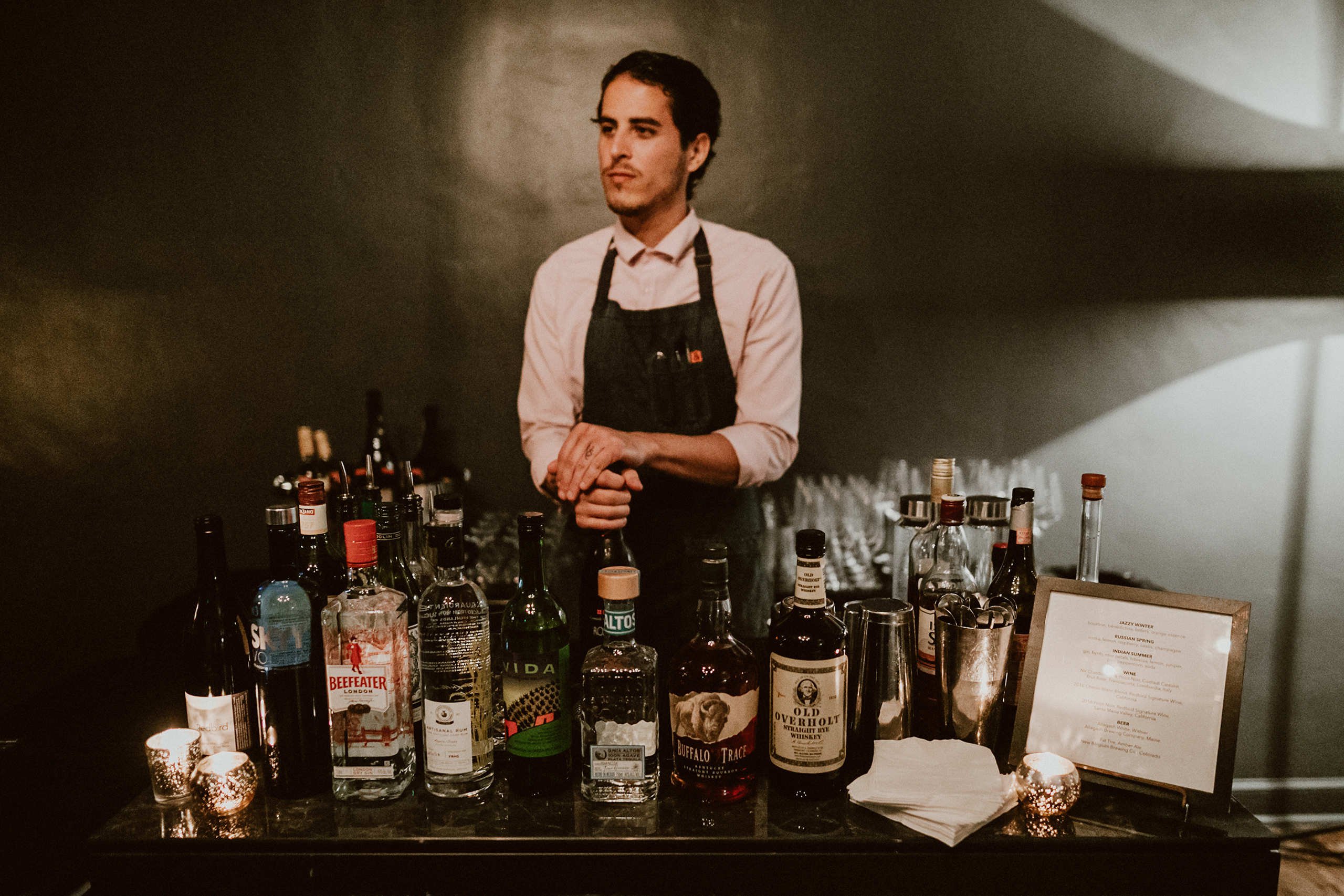 bartender standing in front of bottles