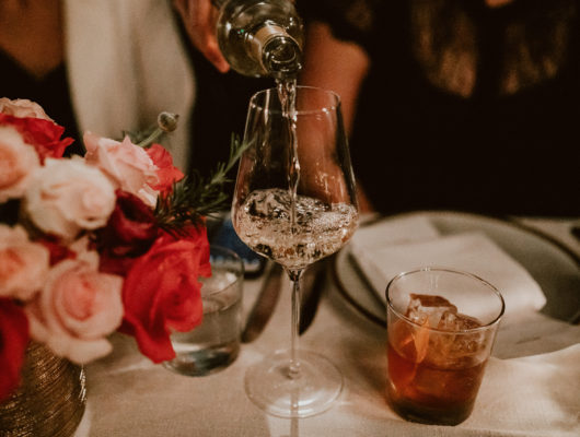 wine being poured with flowers on table