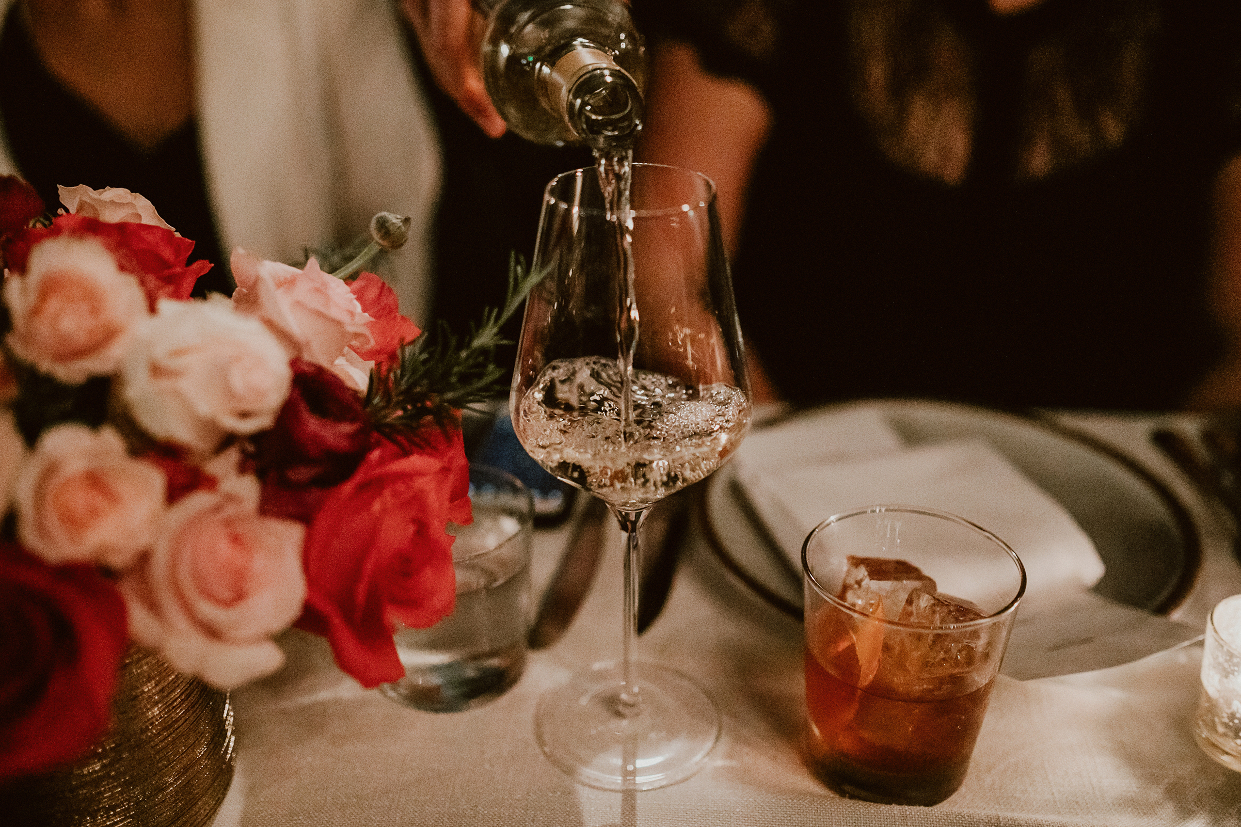 wine being poured with flowers on table