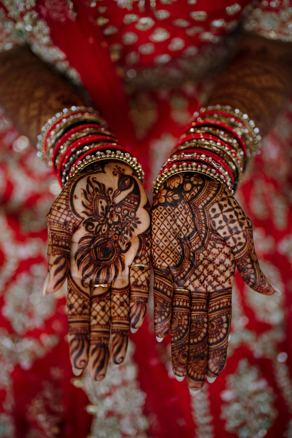 close up of bride's hands with henna and red dress