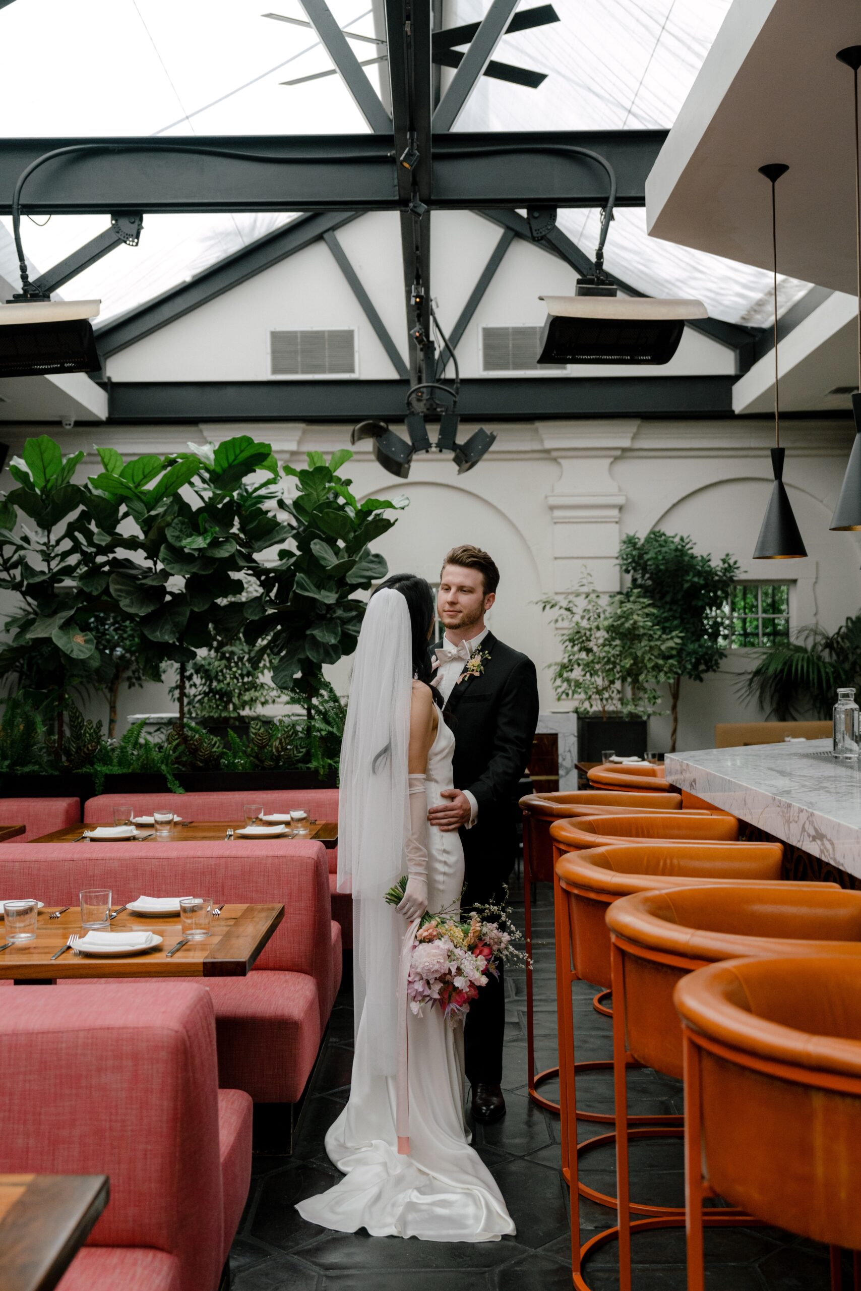 bride and groom at redbird in Los Angeles with orange bar stools