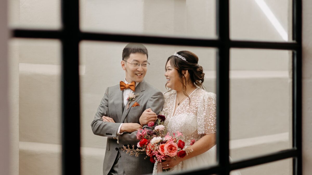 bride and groom through window
