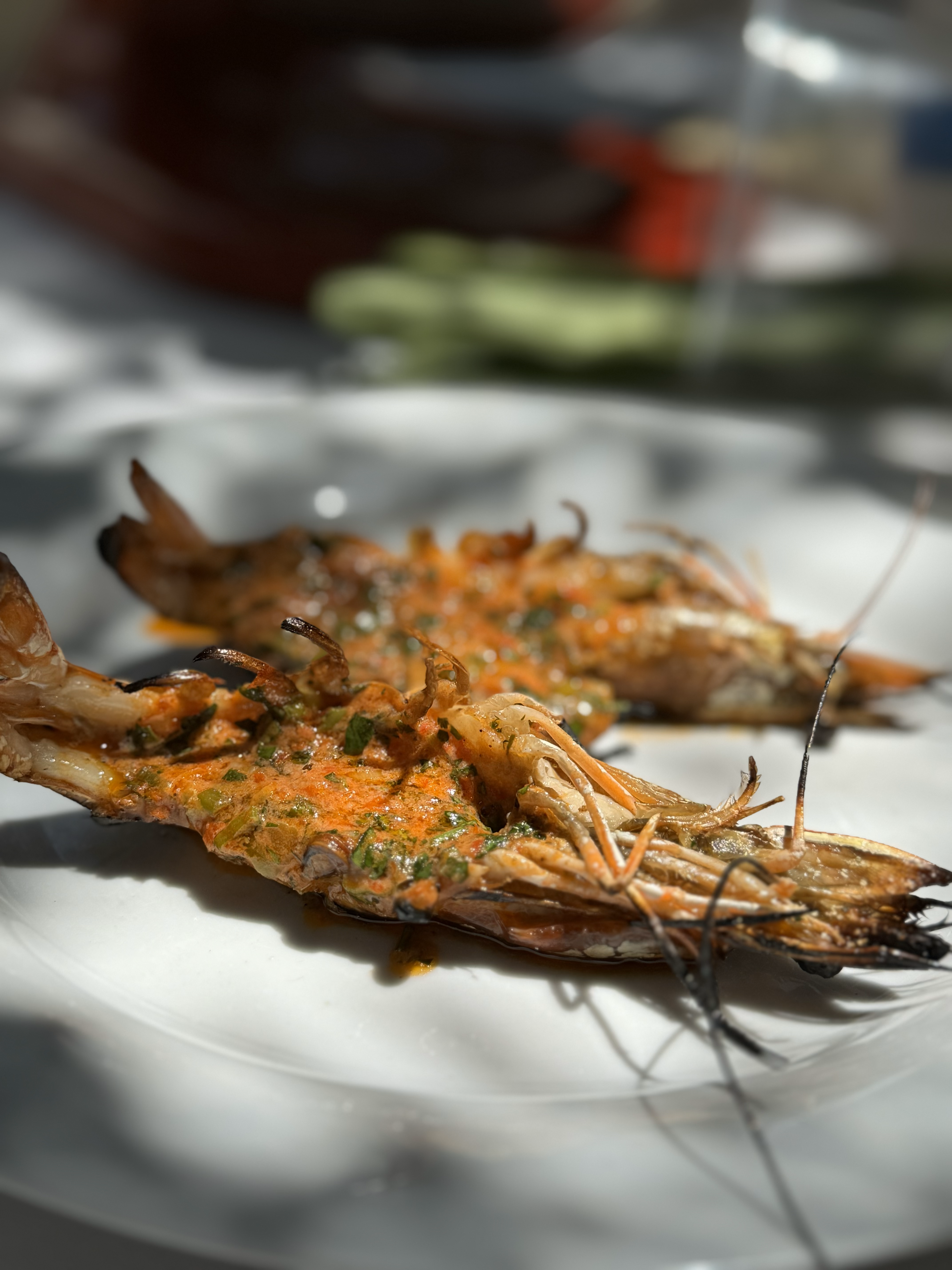 shrimps on a plate with calabrian chili butter on them