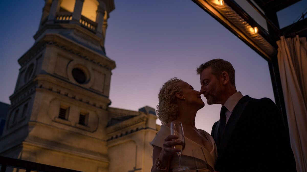 a bride and groom sharing an intimate moment on the balcony